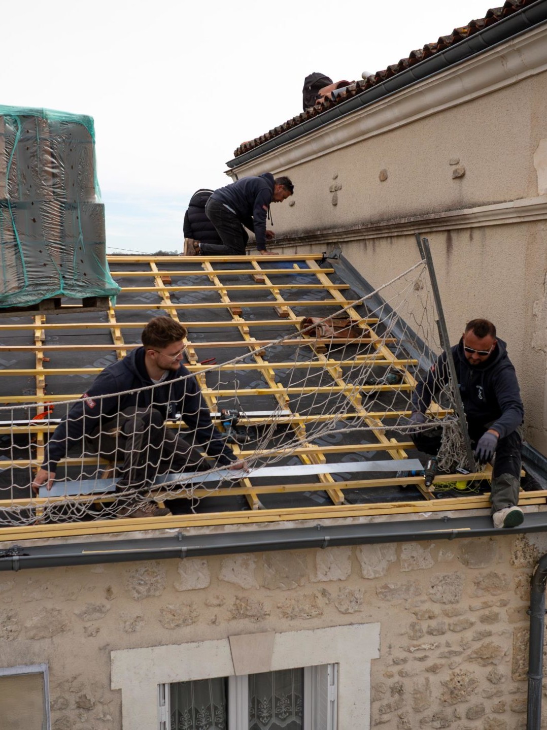 Travailleurs installant une charpente sur un toit.