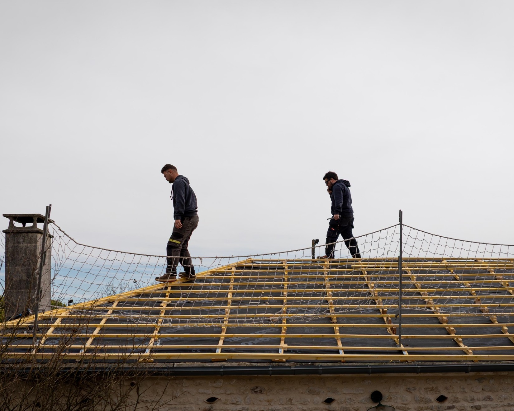 Travailleurs marchant sur un toit en construction.