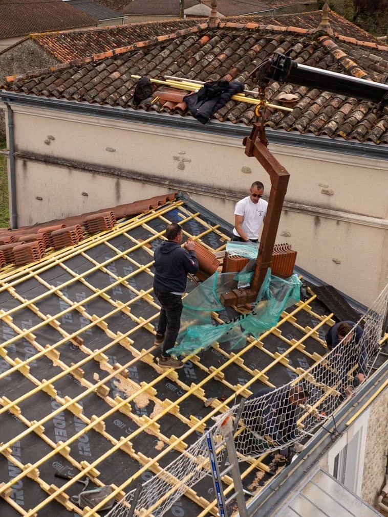 Travailleurs installant un toit en tuiles.