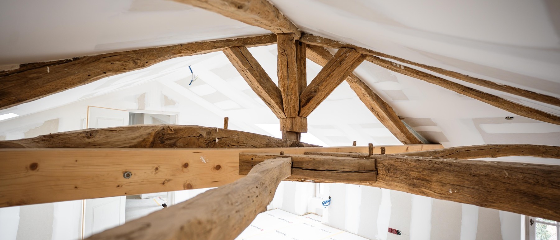 Poutres en bois dans un grenier rénové lumineux.