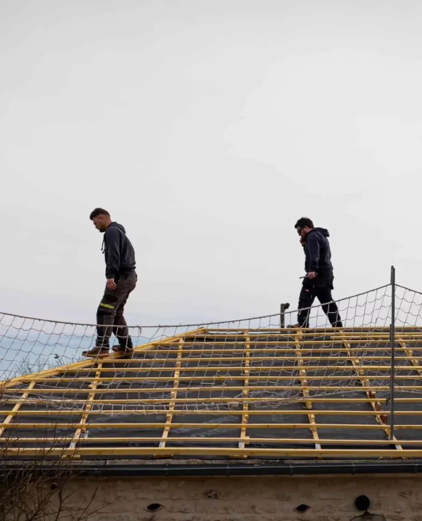 Travailleurs sur charpente de toit sécurisée.